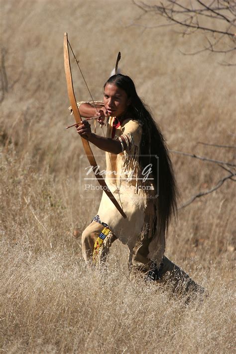 A Young Native American Indian Boy Using Or Hunting With A Bow And