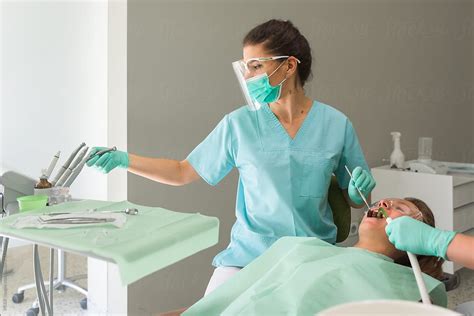 female orthodontist treating her patient in orthodontic office by stocksy contributor ibex