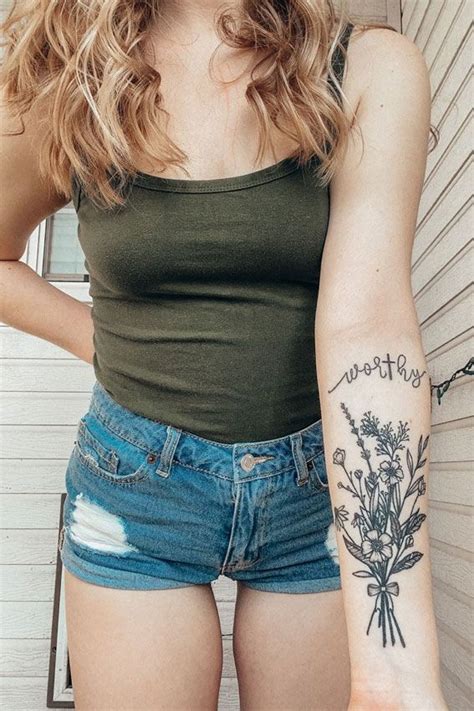 A Woman With A Flower Tattoo On Her Arm