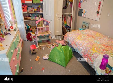Inside A Messy But Well Used Small Girls Bedroom With Toys And Things