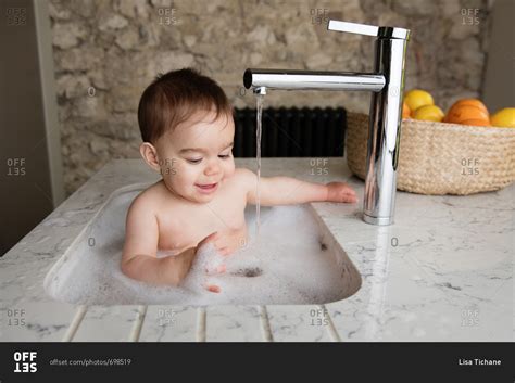 Baby Having A Bubble Bath In The Kitchen Sink Stock Photo Offset