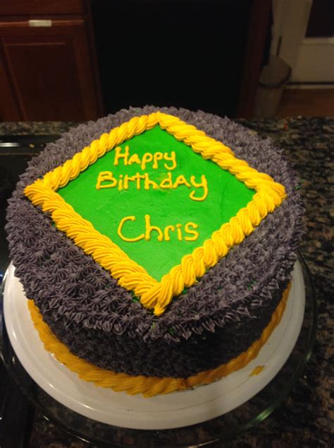A Birthday Cake With Yellow And Green Frosting On A Counter Top In A