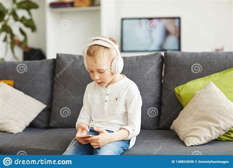 Boy In Headphones Playing Game On Phone Stock Photo Image Of Home