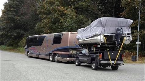 This Rv Is Pulling A Truck With A Boat On Top Of It Rpics