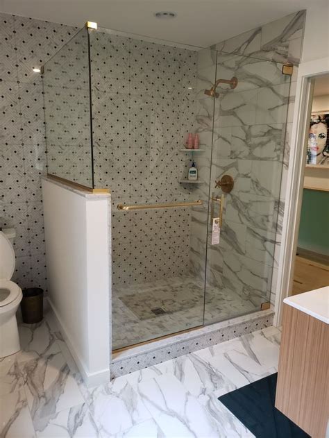 A Bathroom With A Walk In Shower Next To A Toilet