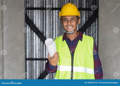 Portrait Male Engineer Wearing Safety Helmet And Holding Blueprint In