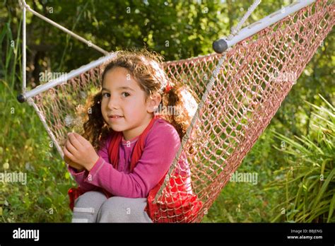 Kleines Mädchen Sitzt In Einer Hängematte Im Garten Stockfotografie Alamy