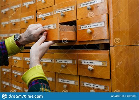 A Person S Hand Opens A Library Card Or File Directory Database