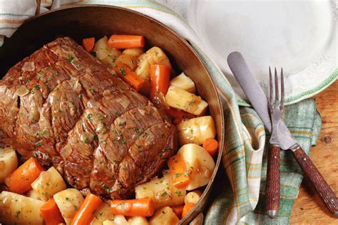The beef and vegetables roast side by side in a shallow pan. Family Pot Roast Recipe with Potatoes and Carrots Recipe