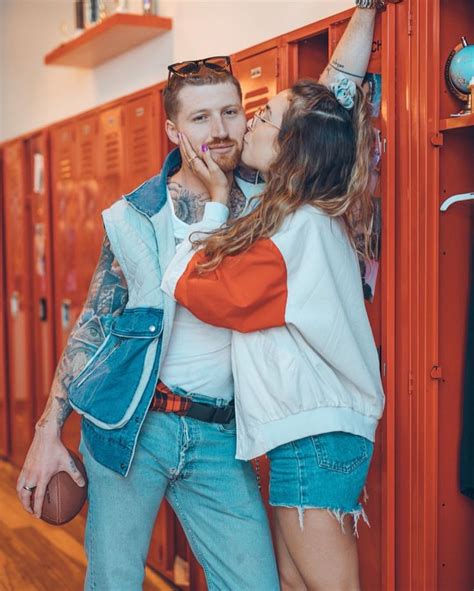 A Man And Woman Kissing In Front Of Lockers