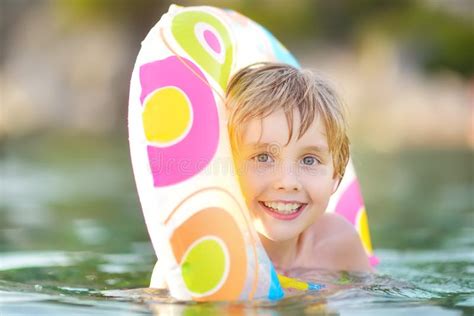 Little Boy Swimming With Colorful Floating Ring In Sea On Sunny Summer