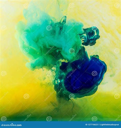 Abstract Swirls Of Green And Blue Paint Flowing In Yellow Water Stock