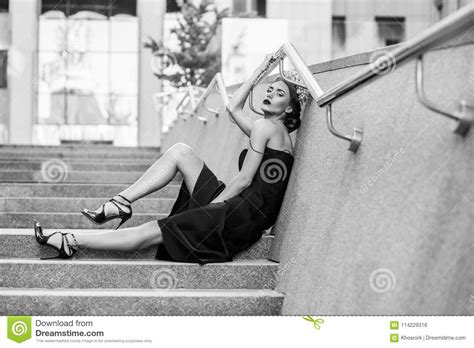 Mulher Atrativa Que Senta Se Em Escadas Da Escadaria Do Granito Foto De Stock Imagem De Povos