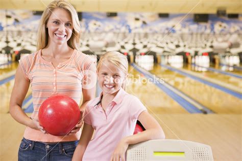 Woman And Young Girl In Bowling Alley Holding Ball And Smiling Royalty