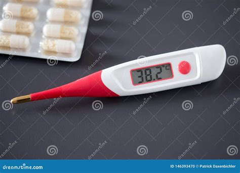 Fever Thermometer And Pills On The Desk 38 Degrees Celsius On The