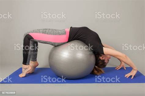 Girl Bending Backwards Over A Gymnastic Ball Stock Photo Download
