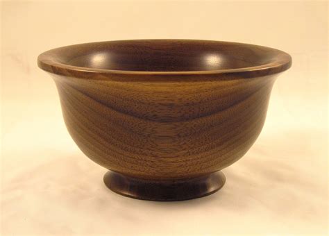 A Wooden Bowl Sitting On Top Of A White Table