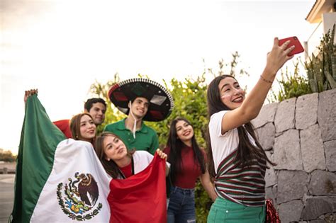 teenager latin friends taking selfies celebrating the mexican soccer team win outdoors stock