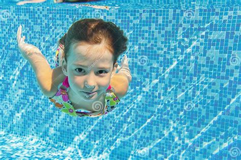 Happy Active Underwater Child Swims And Dives In Pool Stock Photo