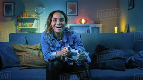 Beautiful Excited Young Black Gamer Girl Sitting On A Couch And Playing Video Games On A Console