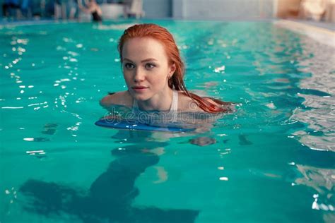 Beautiful Young Redhead Caucasian Girl Swims In The Indoor Swimming