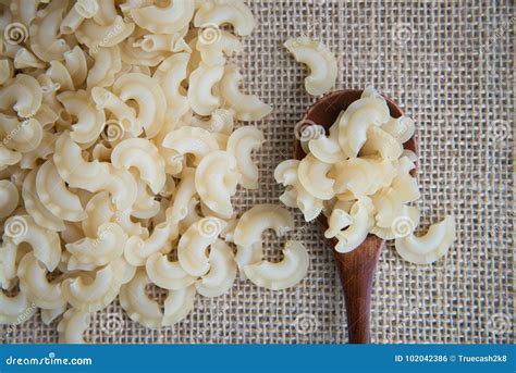 Short Curved And Ruffled Raw Pasta On Rustic Background Natural And