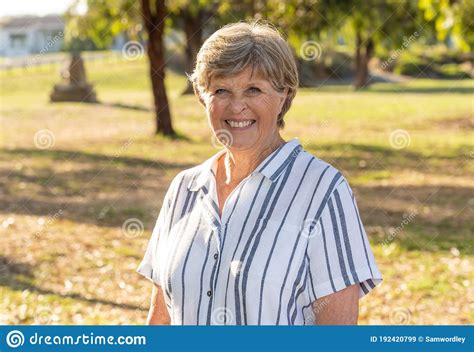 Outdoors Portrait Of Smiling Attractive Senior Woman Walking And
