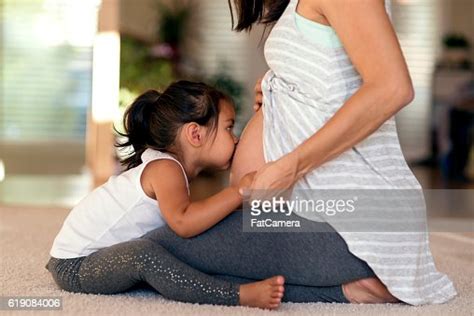 Cute Young Ethnic Girl Kissing Mommys Pregnant Belly Photo Getty Images