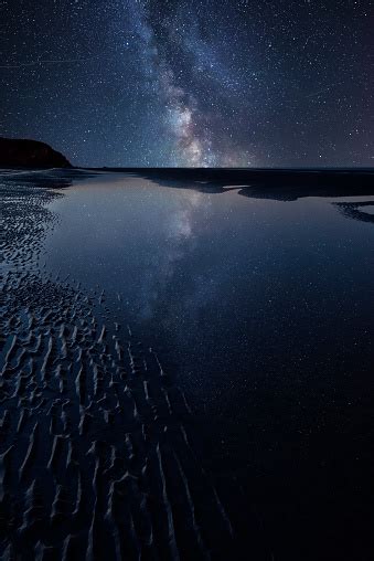 Vibrant Milky Way Composite Image Over Landscape Of Low Tide Beach