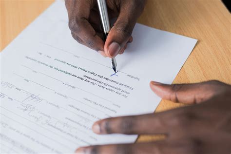 Person Signing Paper · Free Stock Photo