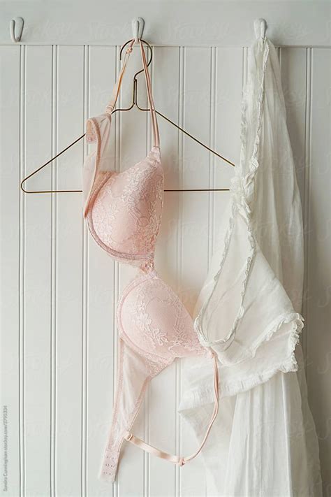 Pink Lace Bras With Nightgown Hanging On Hooks By Stocksy Contributor