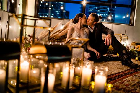 Couple Kiss In Casual Candlelit Setting Against Skyline Photo By John Winters Photography