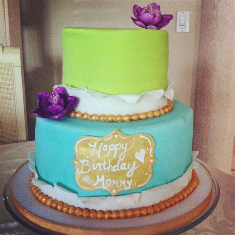 A Brightly Colored Cake With Frills Flowers And Golden Pearls For A