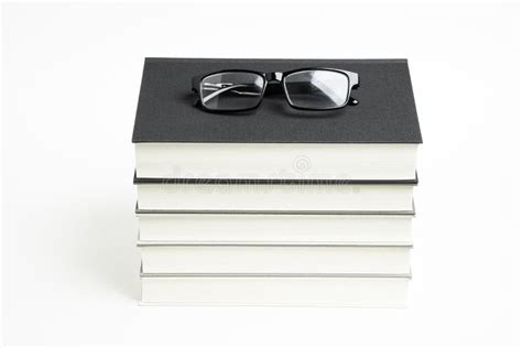 A Neatly Stacked Set Of Five Books With Reading Glasses Stock Photo