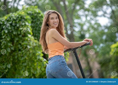 Jeune Fille Aux Cheveux Longs Montant Un Scooter Dans Le Parc Et