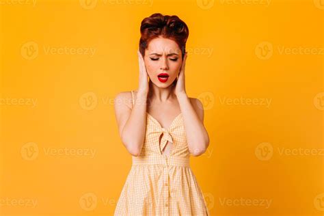Upset Pinup Female Model Covering Ears With Hands Studio Shot Of