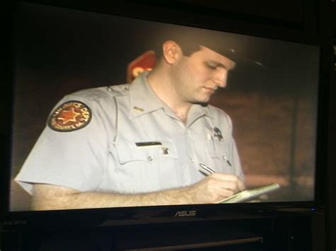 a man in uniform writing on a screen