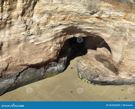 Sunlit Cave In The Cliff With A Smooth Surface Sandy Ground Stock