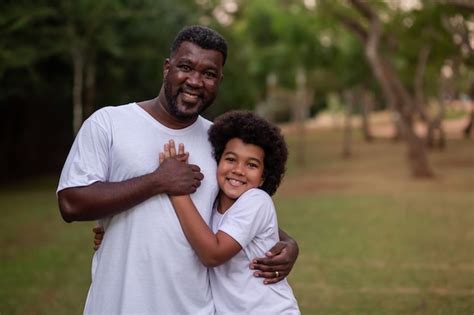 Padre E Hijo Negros En El Parque Abrazados Sonriendo Mirando A La