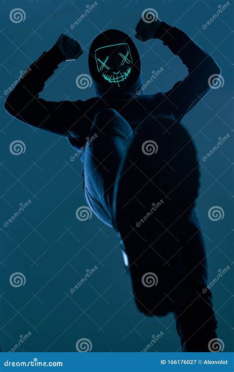 Anonymous Man In Black Hoodie Hiding His Face Behind A Neon Mask Stock Image Image Of
