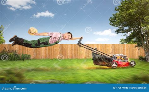 Funny Gardener Being Pulled Through The Garden By A Lawn Mower Stock
