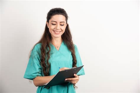 Free Photo Young Female Nurse Writing In Clipboard