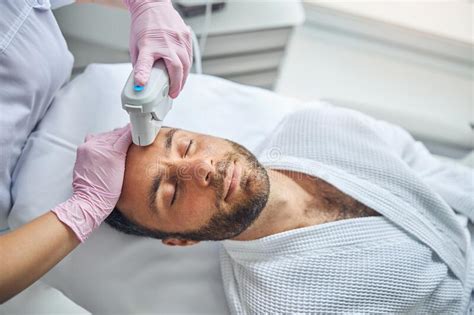 Female Esthetician Treating Male Skin With Laser Device Stock Image