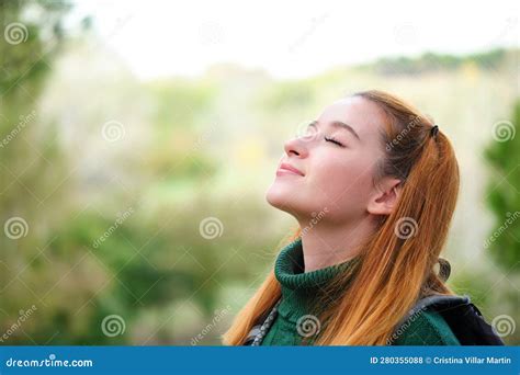 Smiley Redhead Young Woman Breathing Fresh Air Standing Outdoors Stock