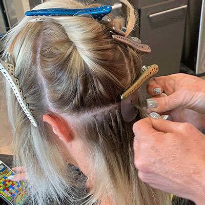 Select a thin strand of hair using the tail of the comb. The Ultimate Hair Extensions Guide | Jyl Craven Hair Design