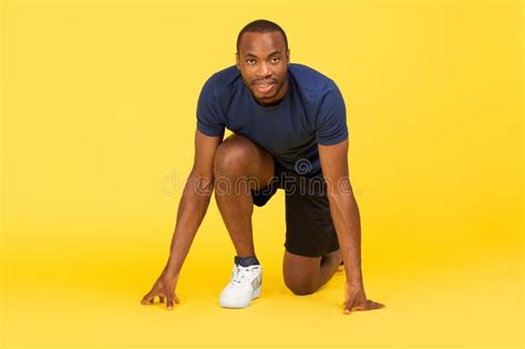 African Male Runner Standing In Crouch Start Position Yellow