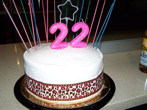 A White Cake With Pink Candles And The Number 22 On It
