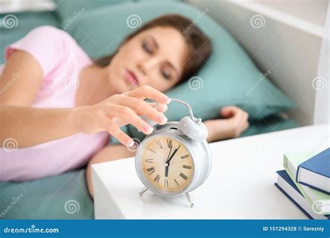 Beautiful Young Woman Trying To Turn Off The Alarm Clock In Morning