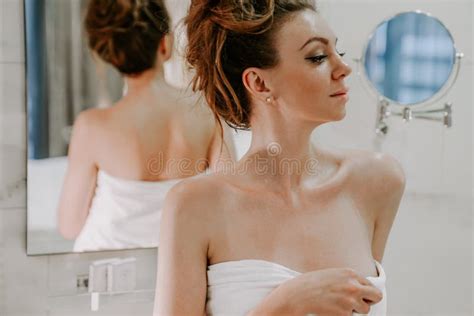 A Beautiful Woman After A Shower In A White Bathrobe Looks In The