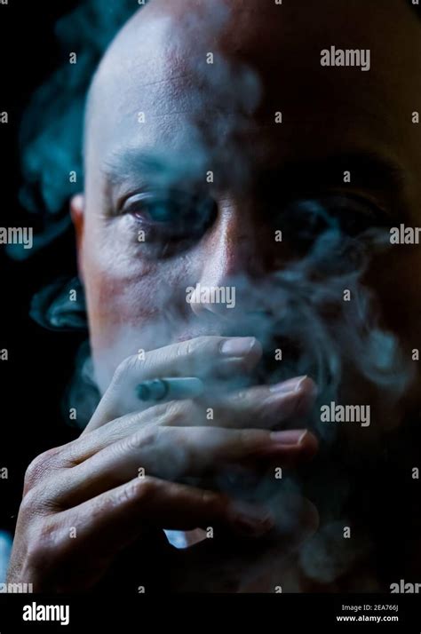 mann raucht eine zigarette und bläst weißen rauch aus stockfotografie alamy